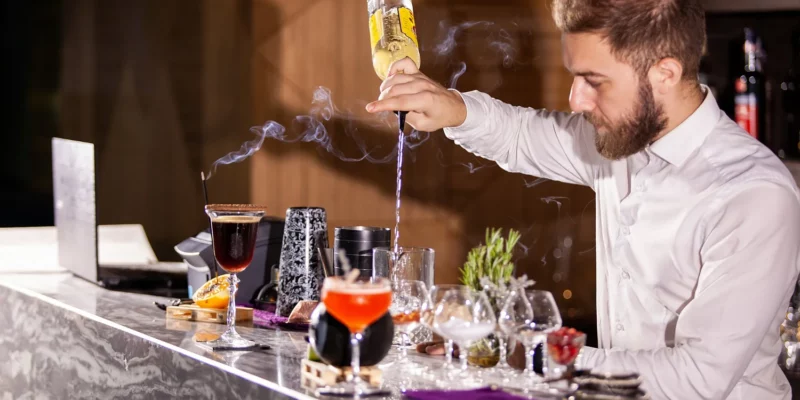 Un barman mixologue en train de préparer des cocktails